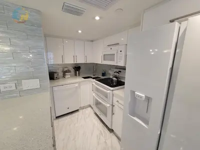 a kitchen with white cabinets and a refrigerator at Alexander 611 in Miami Beach