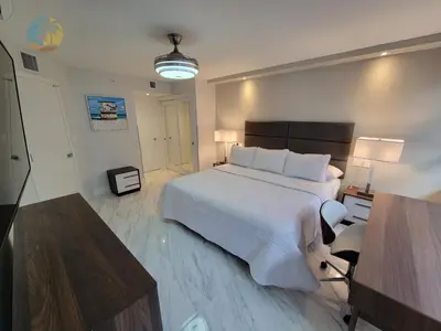 a bedroom with a large white bed and a desk at Alexander 611 in Miami Beach