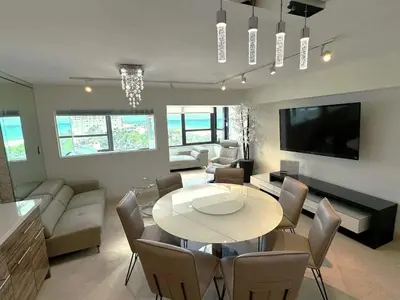 a living room with a table and chairs and a tv at Alexander 702 in Miami Beach