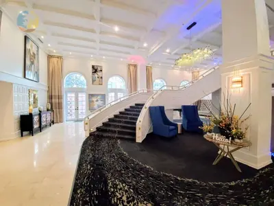 a large lobby with a staircase with blue chairs at Alexander 702 in Miami Beach
