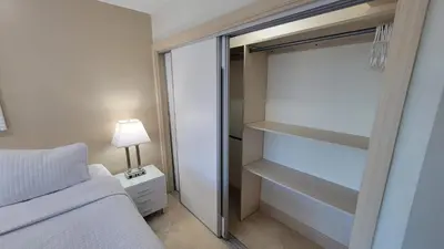 a bedroom with a bed and a glass closet at Alexander 702 in Miami Beach