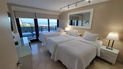 a hotel room with two beds and a mirror at Alexander 702 in Miami Beach