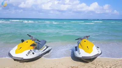 two jet skis sitting on the beach near the ocean at Alexander 718 in Miami Beach