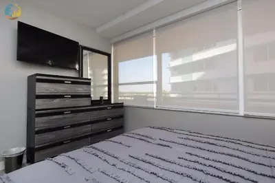 a bedroom with a bed and a tv and a window at Alexander 718 in Miami Beach
