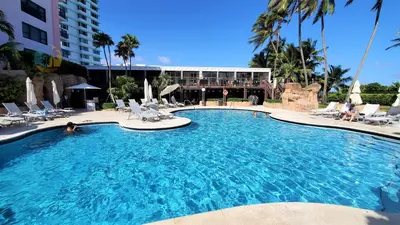 a large swimming pool with chairs and a building at Alexander 807 in Miami Beach
