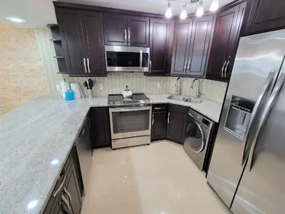 a kitchen with wooden cabinets and stainless steel appliances at Alexander 819 in Miami Beach
