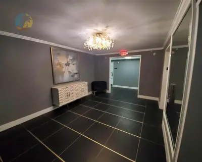 an empty hallway with a chandelier and a room at Alexander 819 in Miami Beach
