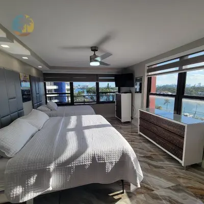 a bedroom with a large bed and large windows at Alexander 81921 in Miami Beach