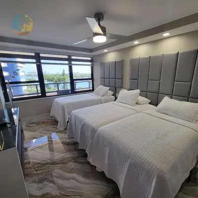 a bedroom with three beds with white sheets and windows at Alexander 821 in Miami Beach