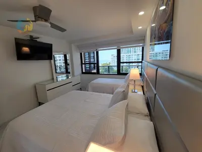 a bedroom with two beds and a tv and two windows at Alexander in Miami Beach