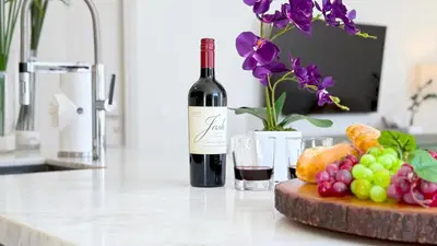a bottle of wine sitting next to a plate of fruit at Tiffany Tides - Resort-Style Beach Townhome - Gym, Rooftop Pool and Sauna in Fort Lauderdale