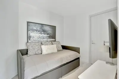 a white room with a couch and a tv at Tiffany Tides - Resort-Style Beach Townhome - Gym, Rooftop Pool and Sauna in Fort Lauderdale