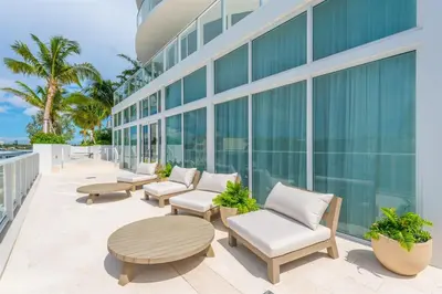 a patio with chairs and tables on a building at Tiffany Tides - Resort-Style Beach Townhome - Gym, Rooftop Pool and Sauna in Fort Lauderdale