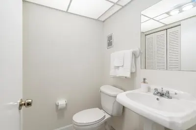 a white bathroom with a toilet and a sink at Serenity Homes in Fort Lauderdale