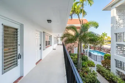 a balcony with palm trees and a swimming pool at Serenity Homes in Fort Lauderdale