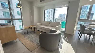 a living room with a couch and a table at Rare Corner Unit Private Terrace & Sunset Views in Miami