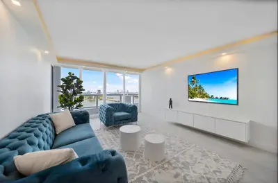 a living room with a blue couch and a tv at The Grand Wonder Biscayne in Miami