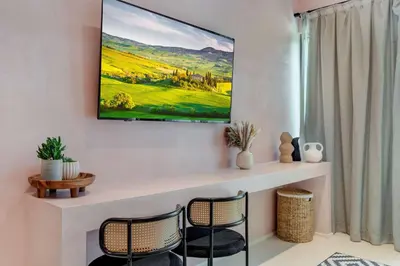 a living room with two chairs and a tv on the wall at Artisan Studio- Breakfast Nook by Design District in Miami