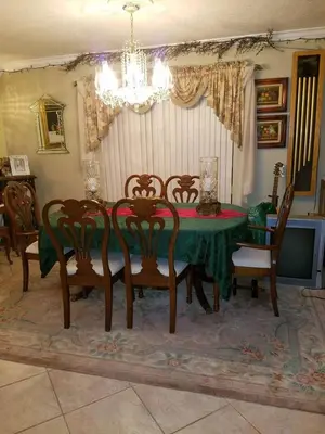 a dining room with a green table and chairs at Flats Hospitality in Plantation