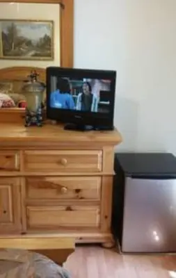 a television on top of a dresser in a bedroom at Flats Hospitality in Plantation
