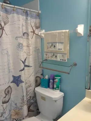 a bathroom with a toilet and a shower curtain at Flats Hospitality in Plantation
