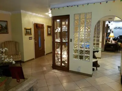 a living room with a glass door and a room with a table at Flats Hospitality in Plantation
