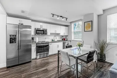 a kitchen with a table and a stainless steel refrigerator at Stylish 1BR Unit With Free Parking Near Wynwood in Miami