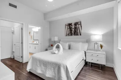 a white bedroom with a white bed with a swan on it at Sunny 1BR Unit With Free Parking Prime Location in Miami