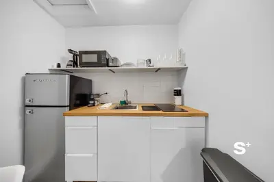 a kitchen with a white refrigerator and a sink at Chic Miami Studio - Gym, BBQ, Free Parking in Miami