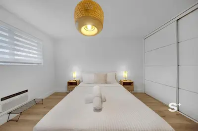 a white bedroom with a large bed and a light at Chic Miami Studio - Gym, BBQ, Free Parking in Miami