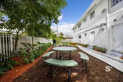 a table and chairs in the courtyard of a building at Stylish Studio - Parking & Gym Near Aventura in Miami