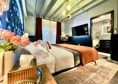a hotel room with a bed and a television at Double Rainbow Suites 24th in Fort Lauderdale