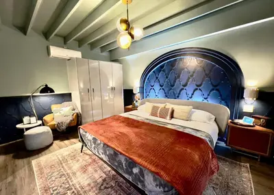 a bedroom with a large bed with a blue headboard at Double Rainbow Suites 24th in Fort Lauderdale