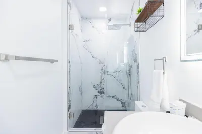 a white bathroom with a shower and a toilet at Havana Casino in Miami