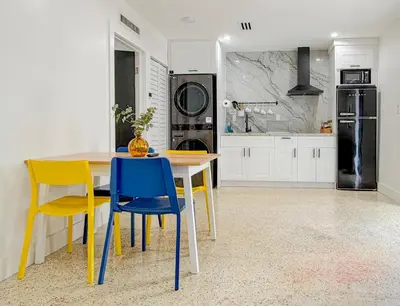 a kitchen with a table and chairs and a refrigerator at Designer 1BR Retreat Heart of Miami Pool in Miami