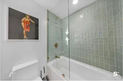 a bathroom with a tub and a picture of a woman on the wall at Skyline 1-BD Condo - City & Ocean View in Miami