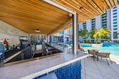 an outdoor bar with a swimming pool and a building at Skyline 1-BD Condo - City & Ocean View in Miami
