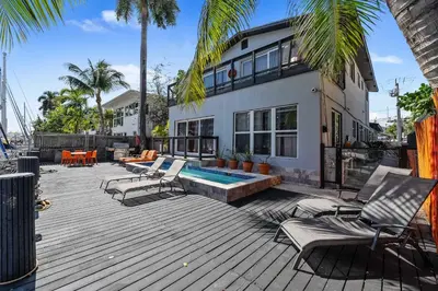 a house with a deck with chairs and a swimming pool at 320-1 Las Olas Boulevard in Fort Lauderdale