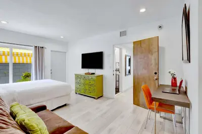 a bedroom with a bed and a desk and a television at Orange Dream on the Water in Fort Lauderdale