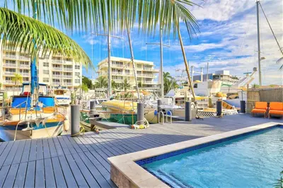 a swimming pool next to a marina with boats at Orange Dream in the Sky in Fort Lauderdale