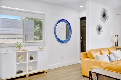 a living room with a yellow couch and a mirror at Orange Dream in the Sky in Fort Lauderdale
