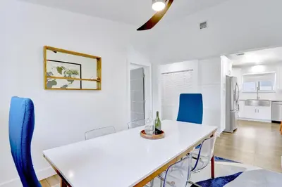 a dining room with a white table and blue chairs at Orange Dream in the Sky in Fort Lauderdale