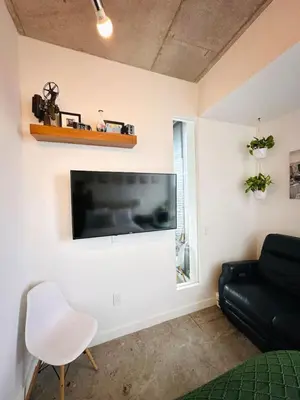 a living room with a large flat screen tv on a wall at Art-filled Loft 180 Views, Rooftop Pool, Parking in Miami