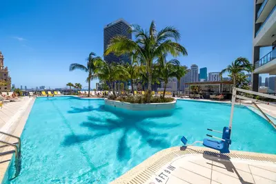 a large swimming pool with palm trees and buildings at Splendid 1 Bed - Amazing views in Miami