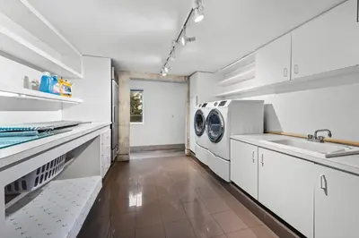 a kitchen with white cabinets and a washer and dryer at Luxury Miami Villa with Large Pool & BBQ, Perfect Getaway! in Miami