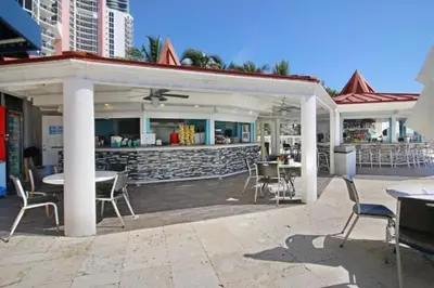 a patio with tables and chairs and a bar at Departamento sobre la Playa con vista a la Collins Ave in Sunny Isles Beach