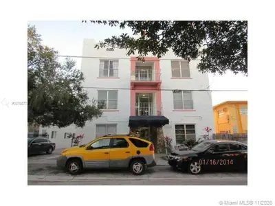 two cars parked in a parking lot in front of a building at Apartamento a 5 minutos de Brickel no amubleado para estancias largas in Miami