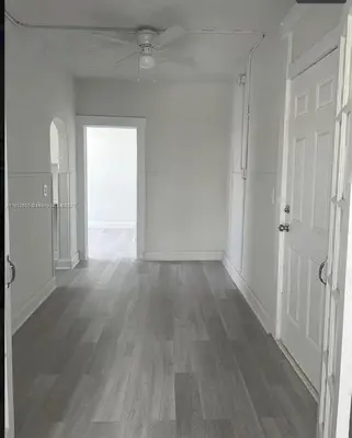 an empty room with white walls and wooden floors and a door at Apartamento a 5 minutos de Brickel no amubleado para estancias largas in Miami