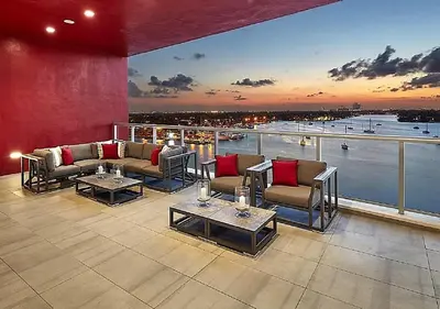 a patio with couches and tables on a balcony at Splendid apartment for 4 pax partial view of the beach in Hollywood M in Hollywood