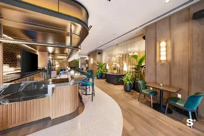 a bar in a hotel lobby with green chairs at Modern DTW Miami Escape with Water Views in Miami